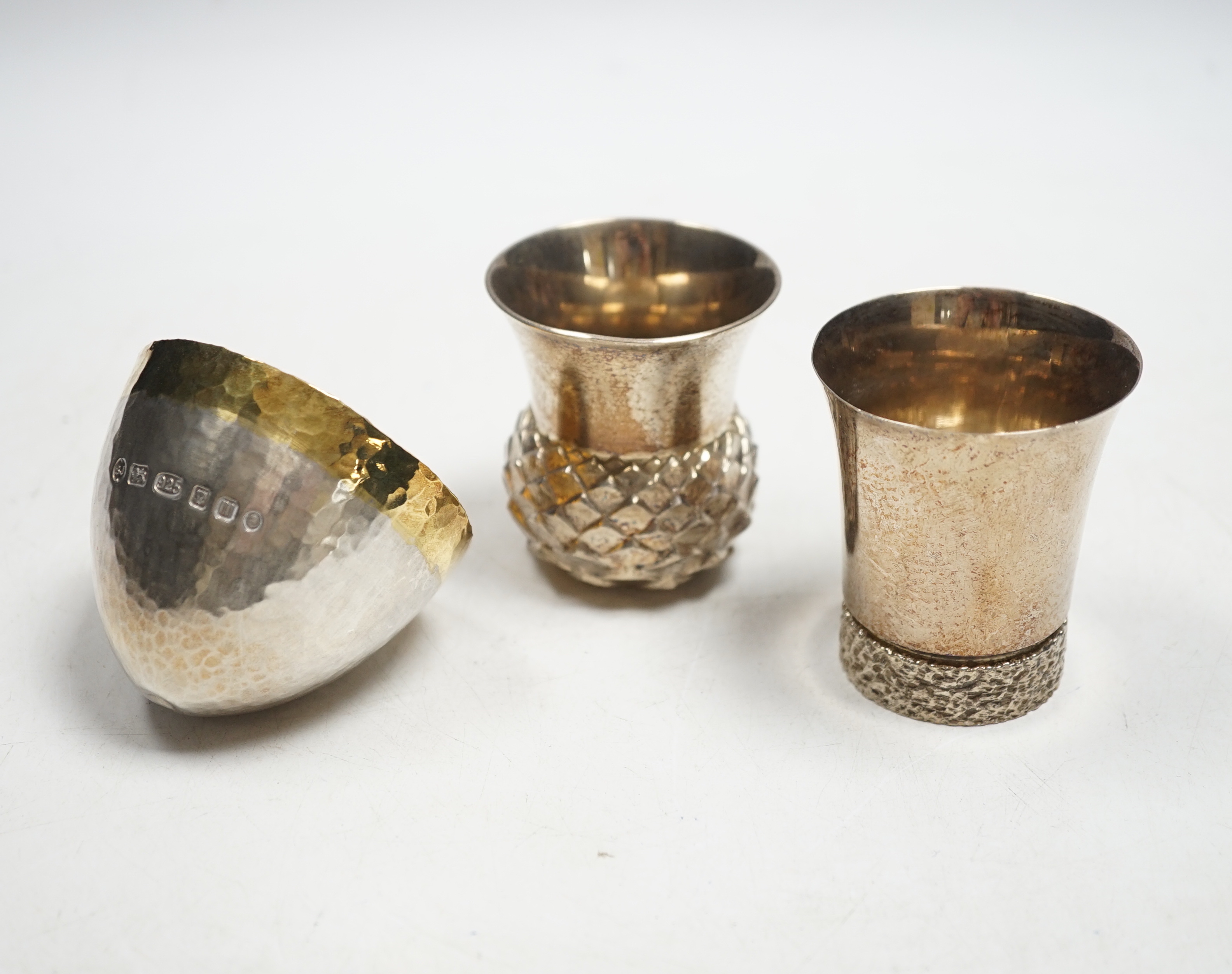 A modern parcel gilt silver tumbler cup, maker Stuart Jenkins, London, 2011 and two modern silver small vases, 10.9oz.